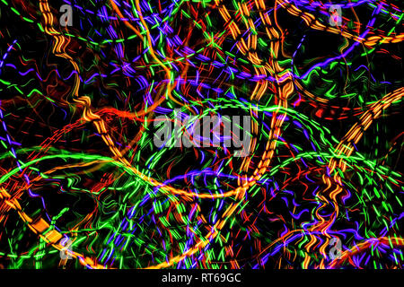 The chaotic lines of color lights on dark background. Colorful lights is move in the black space. Stock Photo