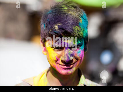 Udaipur, India - March 6, 2015: Portrait of Indian boy with painted face celebrating the colorful festival of Holi on the street.