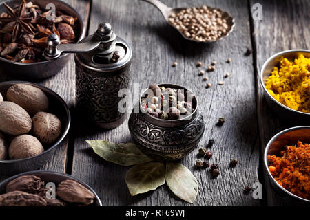 Spices, bronze pepper grinder and spoon with cumin seeds at wooden green  background Stock Photo - Alamy