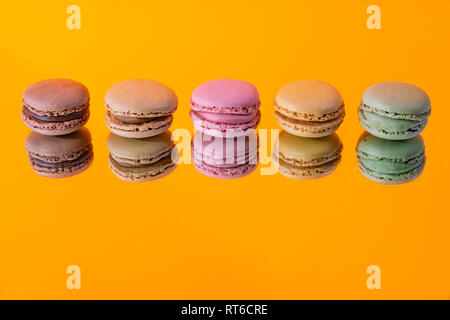 Tasty colorful macaroon homemade isolated on a mirror and a colorful background and reflections contemporary decoration Stock Photo