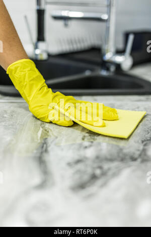 Cropped image of male janitor cleaning counter with detergent spray bottle and sponge Stock Photo