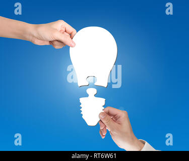 Woman and man two hands assembling one bulb shape puzzle of two jigsaw pieces, isolated on white. Stock Photo