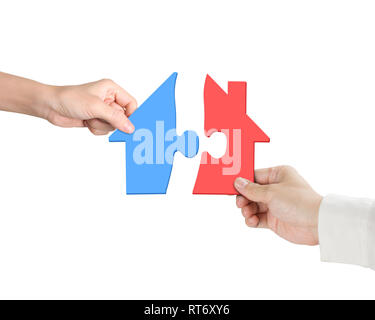 Woman and man two hands assembling house shape puzzles of different color red and blue, isolated on white. Stock Photo