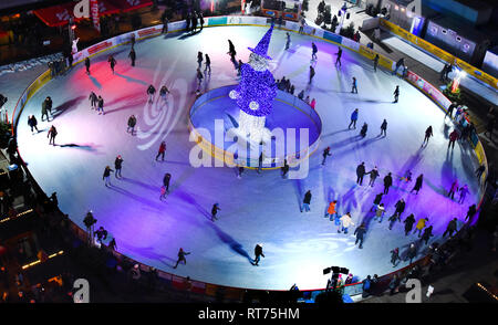 03 February 2019, Saxony, Leipzig: In the middle of the city, many skaters cavort on the round ice rink in front of the opera house. Until the beginning of March, sports enthusiasts will be able to take their laps around the great blue 'Eisaugust' on a total area of 960 square metres. The system offers up to 29 degrees plus ice safety. Photo: Waltraud Grubitzsch/dpa-Zentralbild/ZB Stock Photo