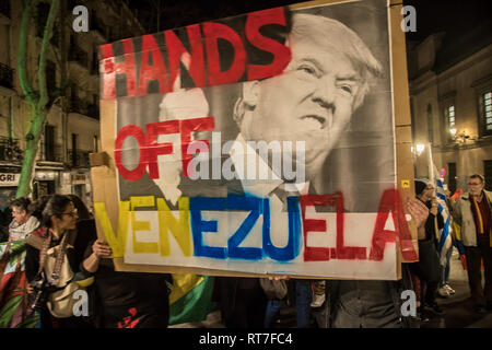 Madrid, Spain. 28th Feb, 2019. March against the military intervention of United States in Venezuela ¨No war intervention¨in Madrid Spain. In the picture people witha big placard ¨hands off Venezuela¨ Credit: Alberto Sibaja Ramírez/Alamy Live News Stock Photo