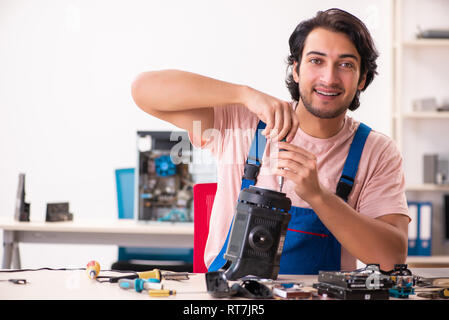 Young male contractor repairing computer Stock Photo