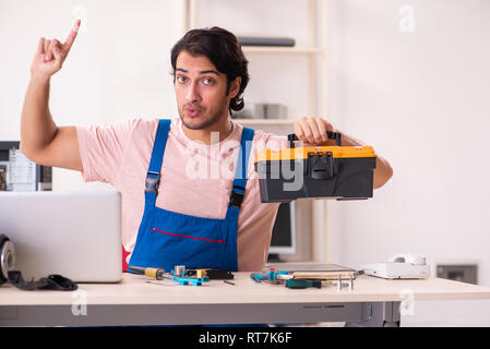 Young male contractor repairing computer Stock Photo