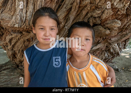 Kazakh brother and sister by a 700 year old willow tree, Altyn Emel National Park, Kazakhstan Stock Photo