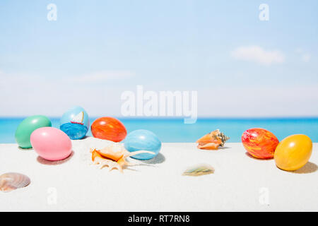 Easter on tropical beach background. Eggs on the white sand. Vacation and travel concept in spring Stock Photo