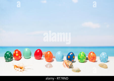 Easter on tropical beach background. Eggs on the white sand. Vacation and travel concept in spring Stock Photo