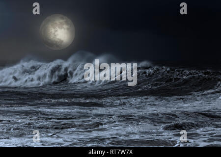 Big white wave approaching the coast in an overcast full moon night Stock Photo