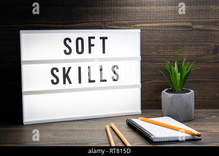 Soft Skills concept. Text in lightbox. Wooden office table Stock Photo