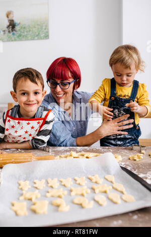 Mother baking cookies with her children Stock Photo