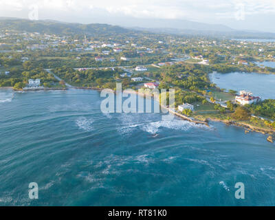 Aerial Drone shot of Jamaica, showing the Caribbean sea, houses and mountain Stock Photo