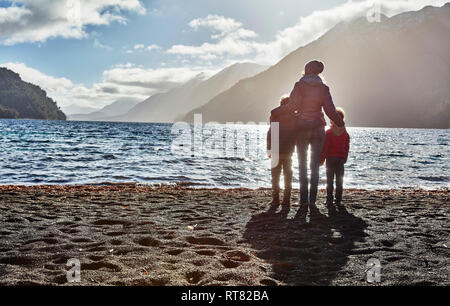 Argentina, Patagonia, Lago Nahuel Huapi, woman with two sons standing at the shore overlooking the lake Stock Photo