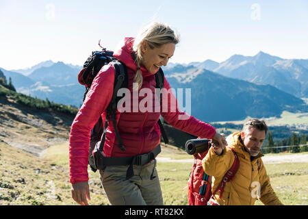 Austria, Tyrol, smiling couple hiking hand in hand in the mountains Stock Photo