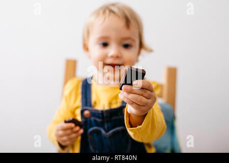 Hand of smiling toddler girl holding piece of chocolate, close-up Stock Photo