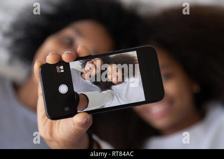African mother daughter photographing showing selfie photo on smartphone Stock Photo