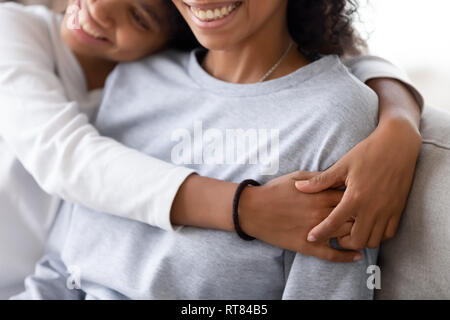 Cropped image of african daughter embracing mother Stock Photo