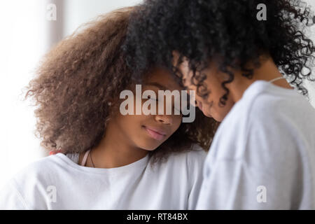 African mother and daughter touching foreheads having close strong connection Stock Photo