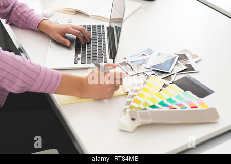 Designer working in office, using laptop, close up Stock Photo