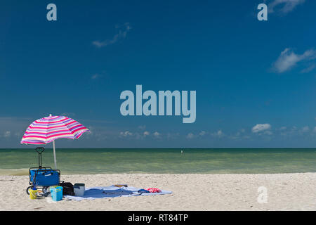 United States of America, Florida, Fort Myers, Sanibel Island, Sanibel, sunshade and beach gear in front of the sea with  blue sky above Stock Photo