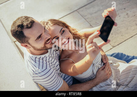 Smiling couple taking selfie with smartphone Stock Photo