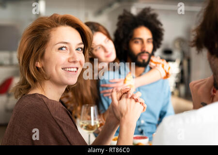 Friends having fun at a dinner party, enjoying eating together Stock Photo