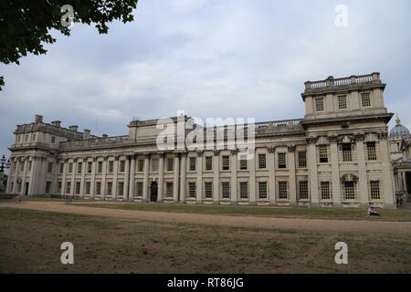 A man sits and reads in front of Trinity Laban, housed in King Charles Court, in the World Heritage Site, Greenwich, in London, United Kingdom. Stock Photo
