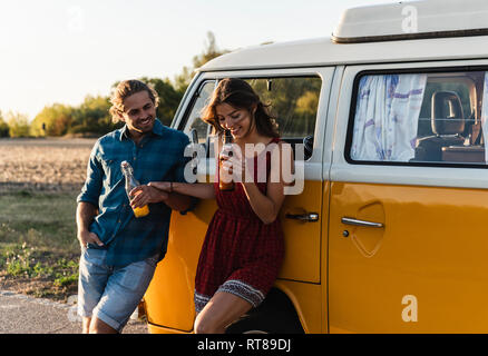 Happy couple taking a break on their road trip, having a drink Stock Photo