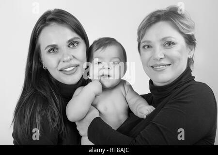 Grandmother, daughter and granddaughter on white portrait, happy family concept. Black and white Stock Photo