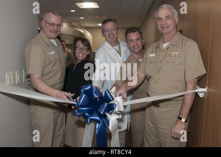 Portsmouth, Va. Radiation Oncology Division leadership and command leadership cut a ribbon during a ceremony at Naval Medical Center Portsmouth (NMCP) for new state-of-the-art equipment that delivers radiation treatment to tumors. From left, Cmdr. Timothy Barkdoll, the Radiation Oncology Division Head; Capt. Carolyn Rice, NMCP’s executive officer; Capt. Scott Rader, Radiology Department head; Capt. Heath Way, director of Clinical Support Services; and Capt. Christopher Culp, NMCP’s commanding officer. The Radiation Oncology Division debuted a new Varian TrueBeam linear accelerator during the J Stock Photo