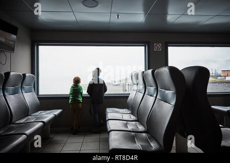 Chile, Puerto Montt, two boys looking out of window of a ferry Stock Photo