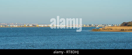 Panoramic view across Christchurch Harbour of beach huts on Mudeford Spit, Hengistbury Head, Christchurch, Dorset, UK Stock Photo