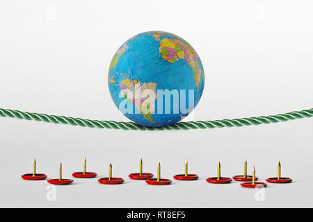 Planet earth balancing on rope over push pins - Concept of health planet and environmental risks Stock Photo