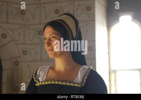 A beautiful but sad dark haired Tudor Woman in authentic Tudor dress looks in to camera- she is lady in waiting to Anne Boleyn Stock Photo