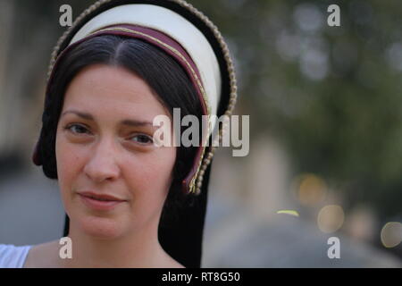 A beautiful but sad dark haired Tudor Woman in authentic Tudor dress looks in to camera- she is lady in waiting to Anne Boleyn Stock Photo