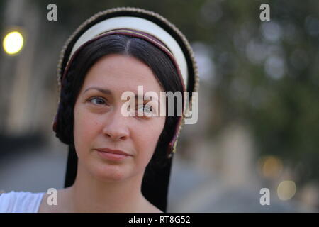 A beautiful but sad dark haired Tudor Woman in authentic Tudor dress looks in to camera- she is lady in waiting to Anne Boleyn Stock Photo