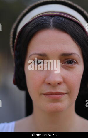 A beautiful but sad dark haired Tudor Woman in authentic Tudor dress looks in to camera- she is lady in waiting to Anne Boleyn Stock Photo