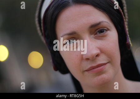 A beautiful but sad dark haired Tudor Woman in authentic Tudor dress looks in to camera- she is lady in waiting to Anne Boleyn Stock Photo