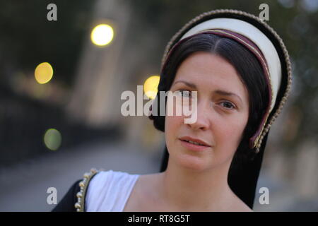 A beautiful but sad dark haired Tudor Woman in authentic Tudor dress looks in to camera- she is lady in waiting to Anne Boleyn Stock Photo
