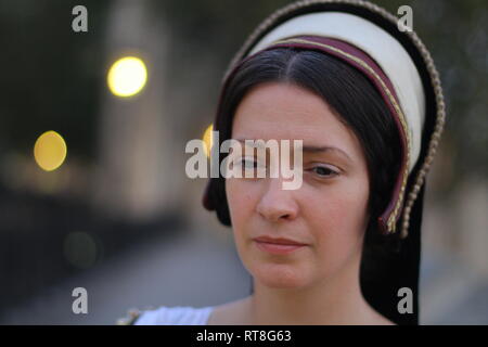 A beautiful but sad dark haired Tudor Woman in authentic Tudor dress looks in to camera- she is lady in waiting to Anne Boleyn Stock Photo