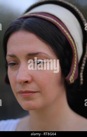 A beautiful but sad dark haired Tudor Woman in authentic Tudor dress looks in to camera- she is lady in waiting to Anne Boleyn Stock Photo