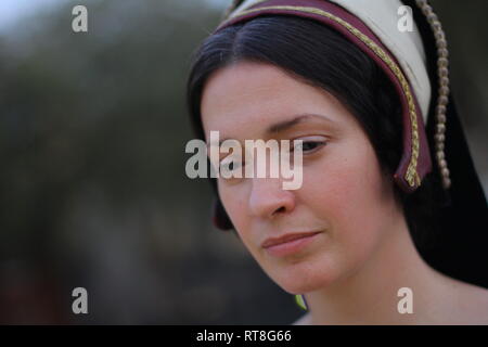 A beautiful but sad dark haired Tudor Woman in authentic Tudor dress looks in to camera- she is lady in waiting to Anne Boleyn Stock Photo