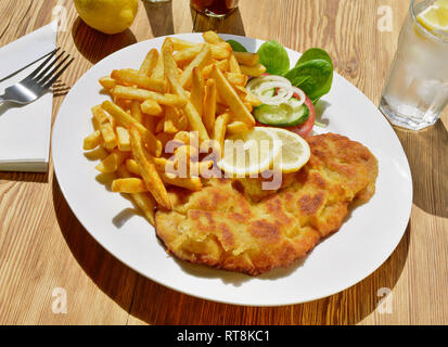 Schnitzel with French Fries on wooden Background Stock Photo