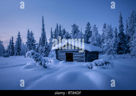 Small hay barn at winter morning blue hour covered by snow in Finland Stock Photo