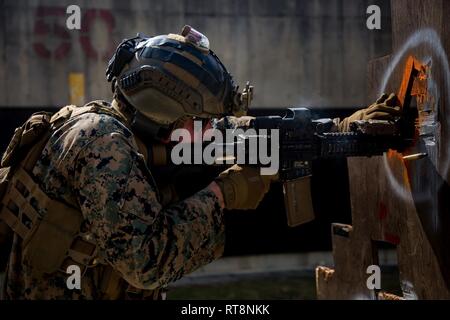 Marines with 3rd Reconnaissance Battalion, 3rd Marine Division, practice live-fire barricade drills on Camp Hansen, Okinawa, Japan, Jan. 29, 2019. The training is designed to improve the unit’s reaction to fire between small openings in walls, as well as to improve overall mission readiness. Stock Photo