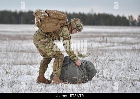 The commander of 4th Battalion, 319th Field Artillery Regiment, 173rd Airborne Brigade, U.S. Army Lt. Col James H.B. Peay recovers his parachute after a training jump with multinational partners from United Kingdom, Germany and Spain at the 7th Army Training Command's Grafenwoehr Training Area, Germany, Jan. 29, 2019. Stock Photo