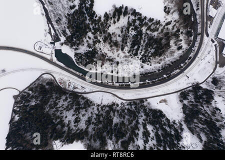 Aerial view of the winter mountain range, the flowing river and highway during day Stock Photo