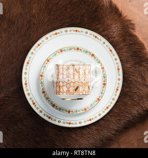White porcelain plates of various sizes and a circle with an ornament lie on a textured brown background. Flat layout. Stock Photo